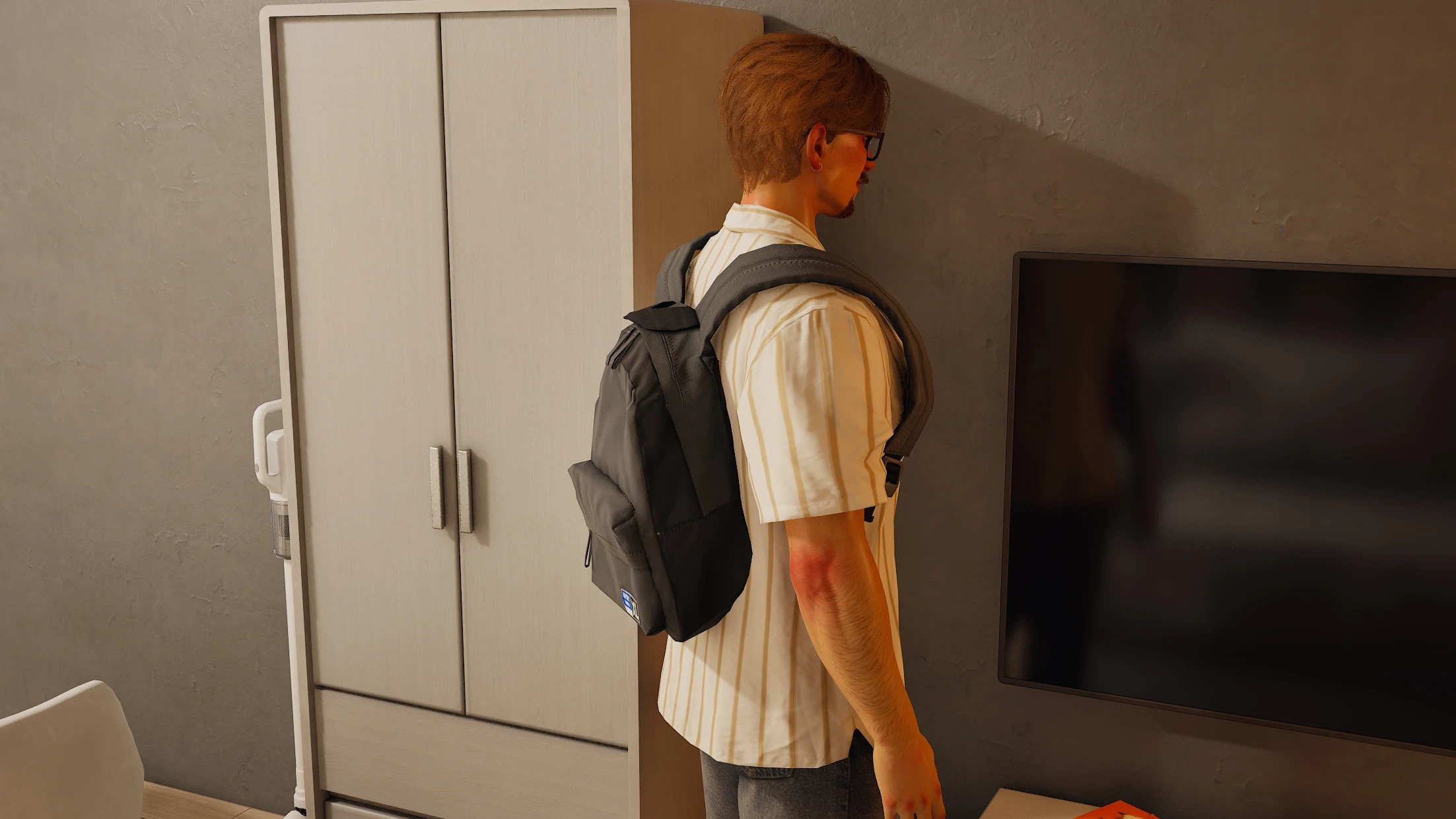 A Zoi wearing a dark backpack stands inside a bedroom.