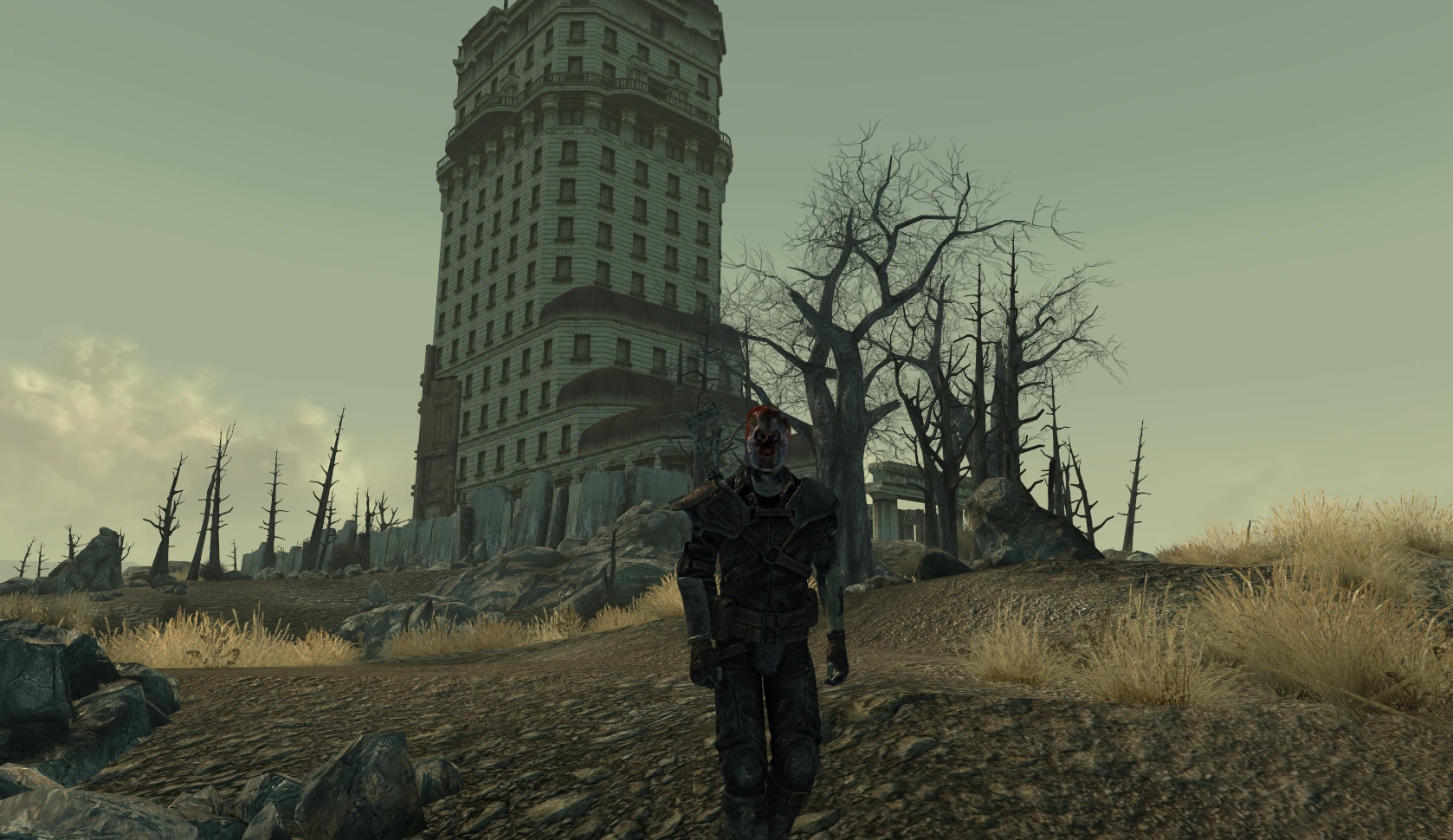 A character wearing the ghoul mask stands in front of Tenpenny Tower in a Fallout wasteland.