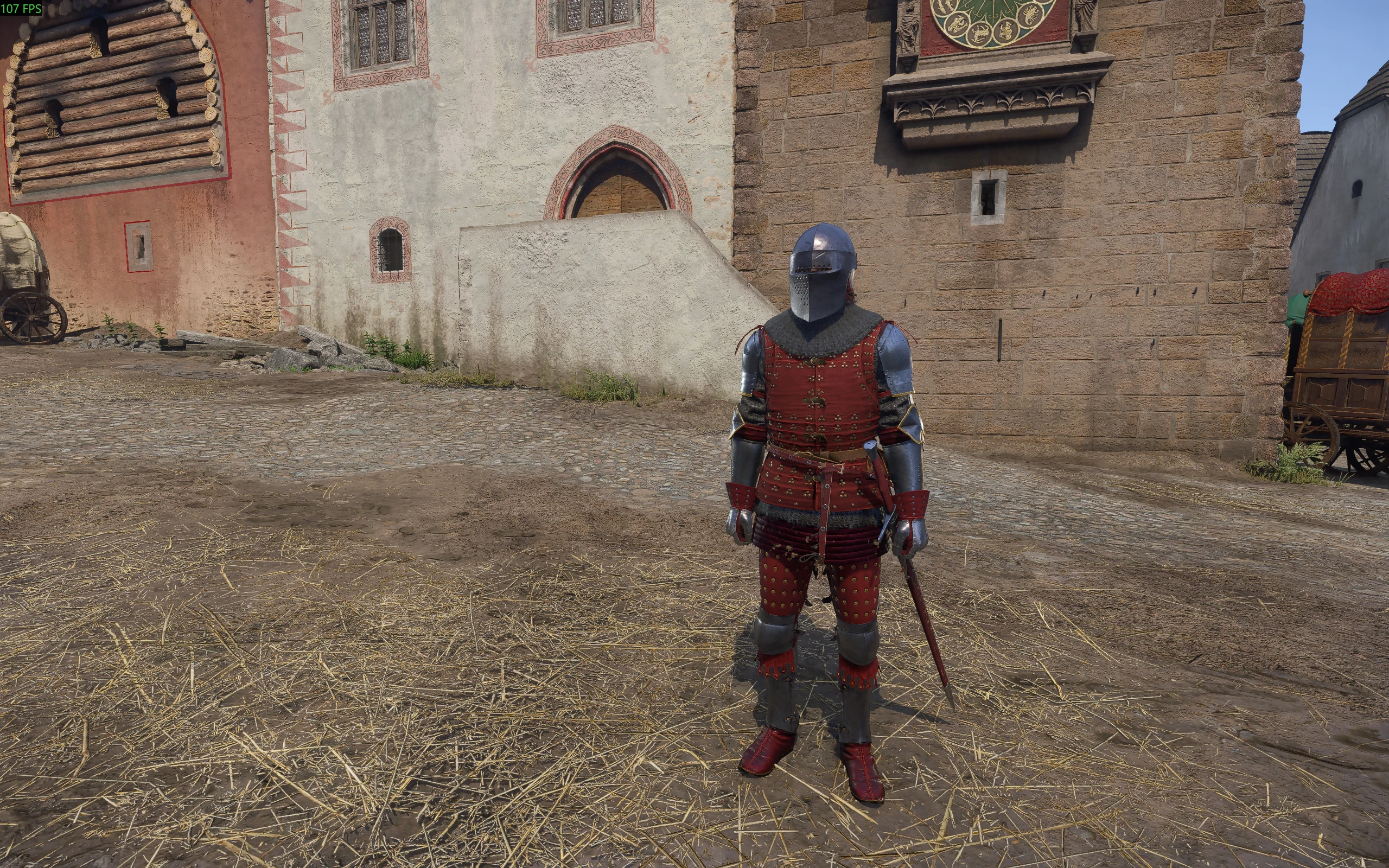 An armored character wearing red brigandine, a closed helmet and plate protection stands in a medieval town square.