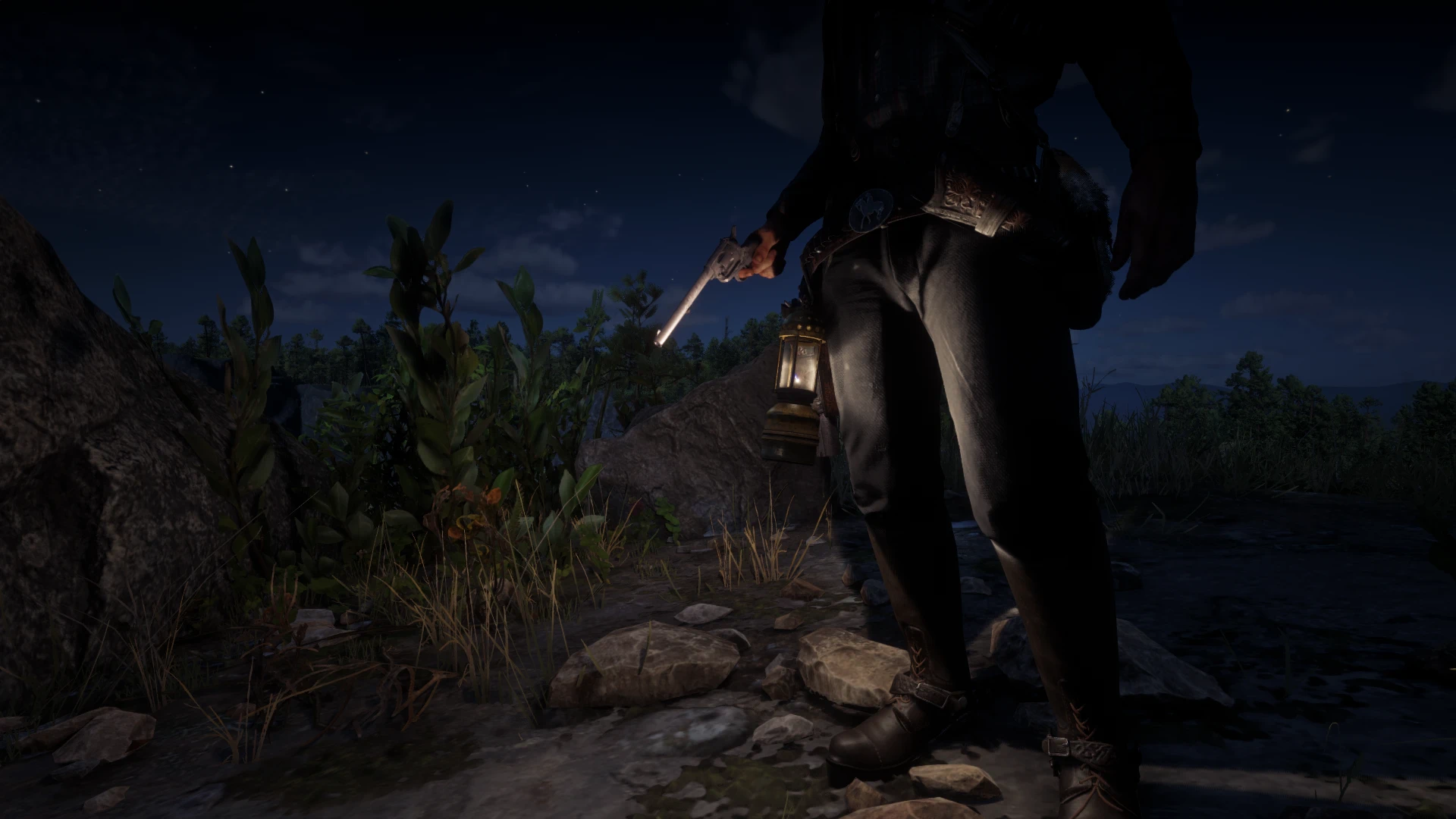 A lantern hangs from the front of the player character’s gun belt beside a drawn revolver at night in Red Dead Redemption 2.
