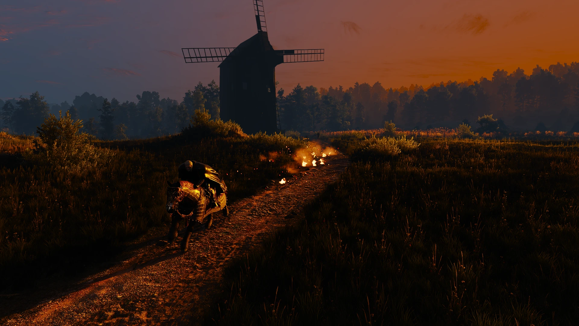 Geralt rides an armored horse along a dark rural track, with flames behind him and a windmill against an orange evening sky.