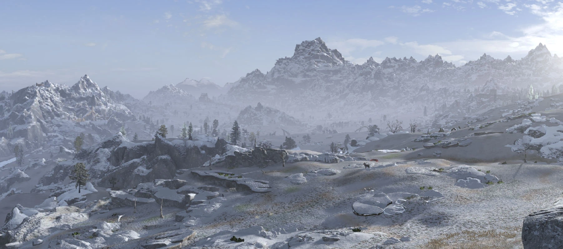 Low winter sunlight casts long mountain shadows across a snowy Skyrim valley.