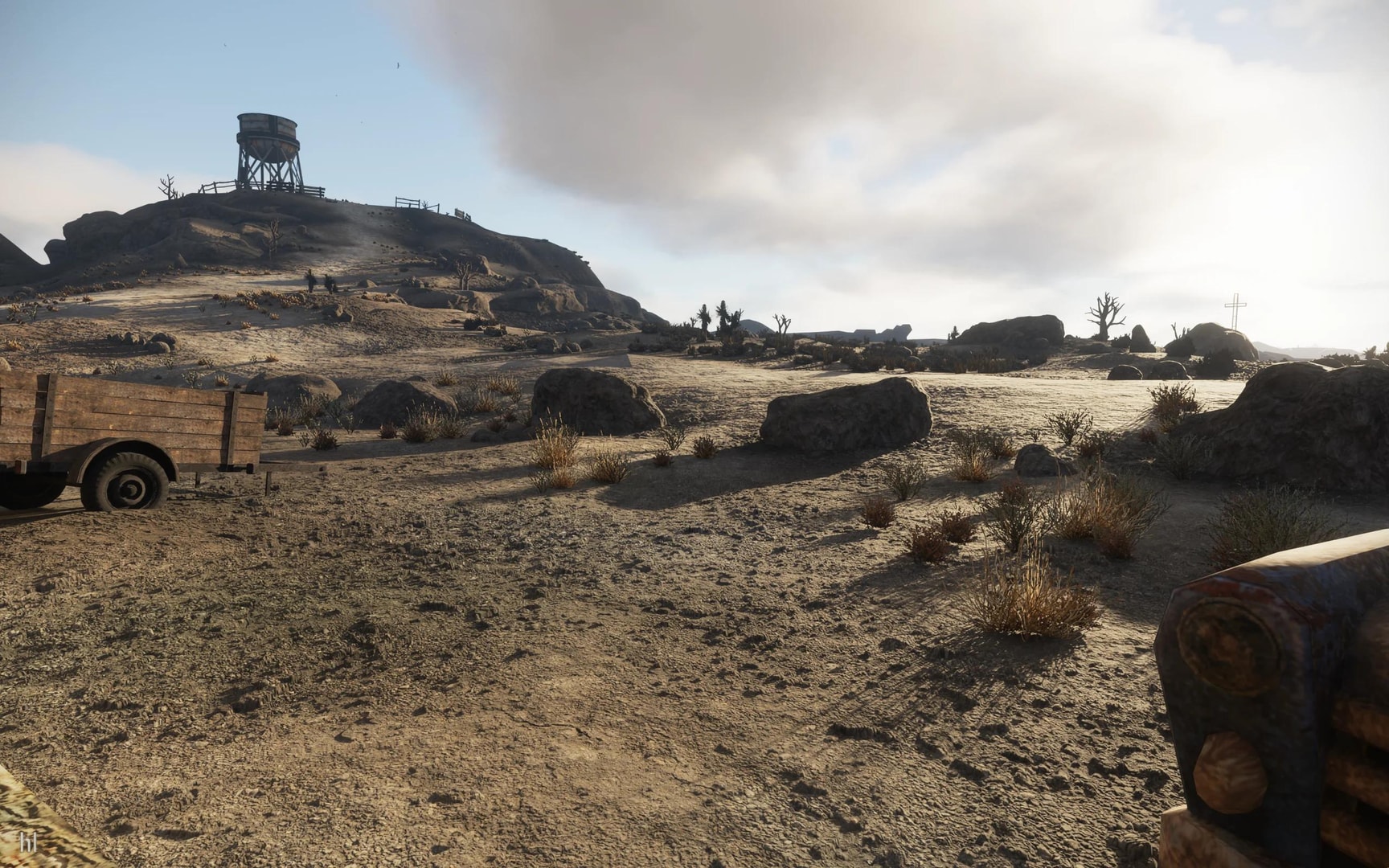 Sunlight falls across rocky Mojave terrain, a trailer and a hilltop water tower in Fallout: New Vegas RTX.