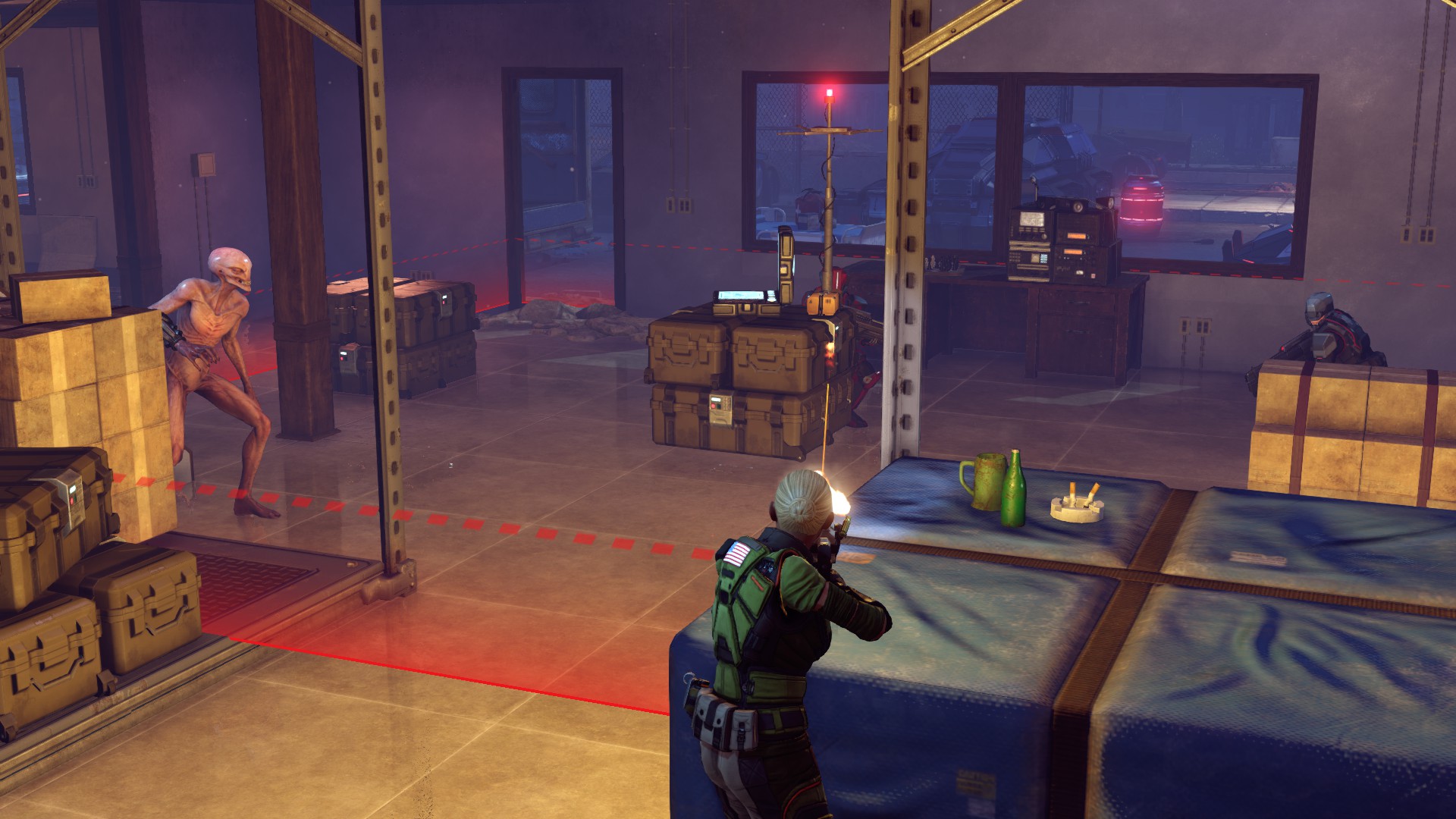 An XCOM soldier fires toward enemies around a marked control point inside a building.