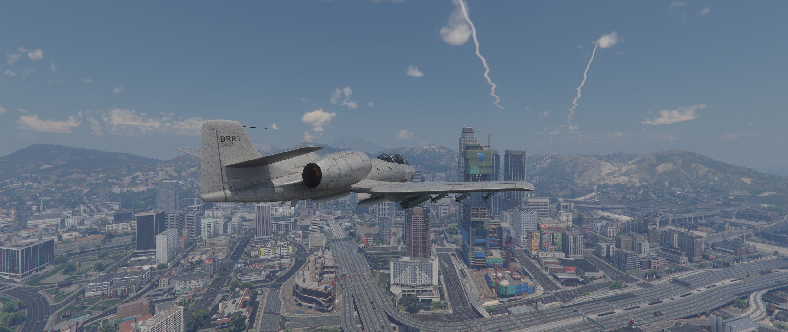 A gray jet flies above Los Santos beneath scattered clouds in an AuraV creator screenshot.