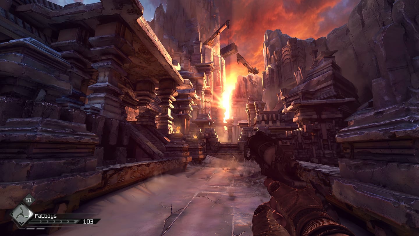 RAGE canyon settlement at orange sunset, showing rock textures and metal buildings with a pistol in the foreground.
