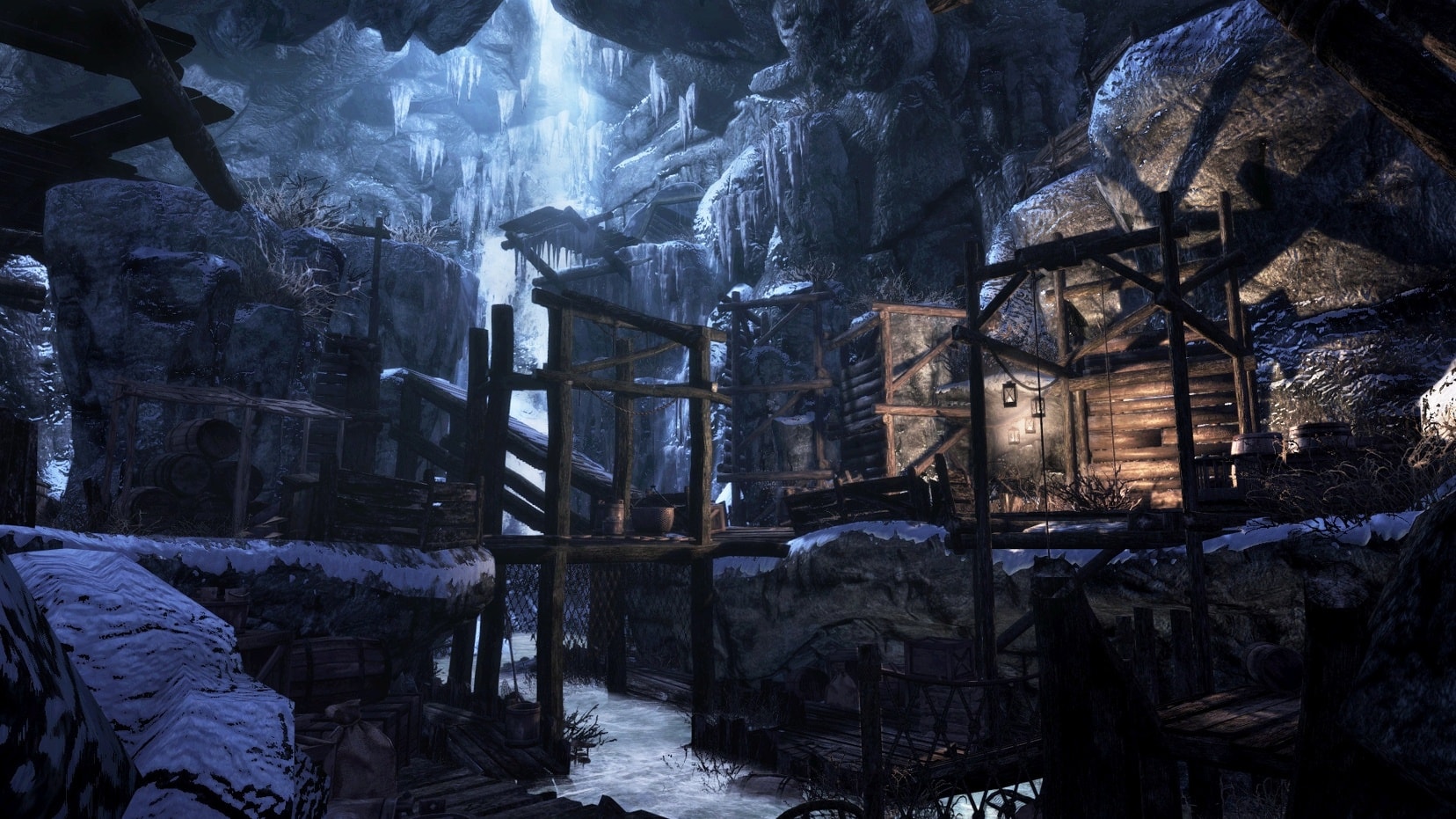 Wooden platforms and buildings inside a blue-lit, ice-covered cavern in Enderal.